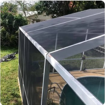 Rescreened pool cage with new black mesh against a clear sky
