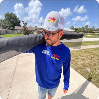 A roll of new screen mesh being carried to a job in an Osky Re-Screen shirt